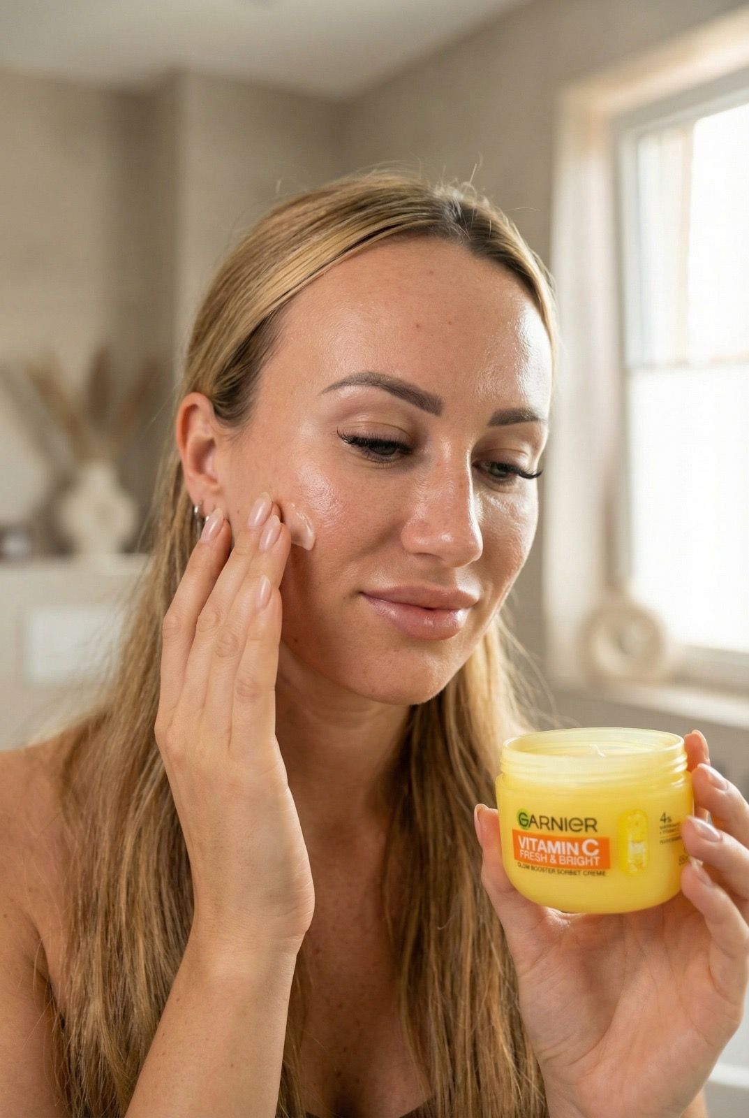 Emina am Fenster bei Tageslicht mit einer Creme